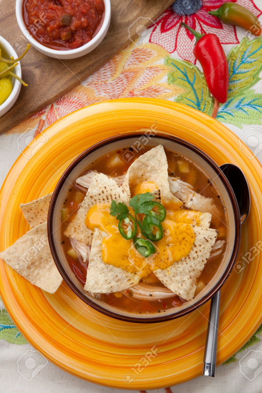 Closeup of a bowl of hot delicious spicy chicken nacho soup, garnished with melted cheese, jalapeno pepper, and fresh cilantro. - 168636706 Closeup of a bowl of hot delicious spicy chicken nacho soup, garnished with melted cheese, jalapeno pepper, and fresh cilantro. - 168636706