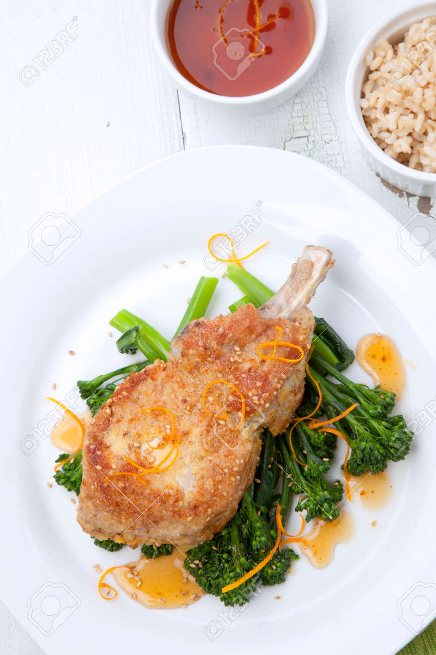 Closeup of sesame-crumbed pork chops with asian greens. - 172126061 Closeup of sesame-crumbed pork chops with asian greens. - 172126061