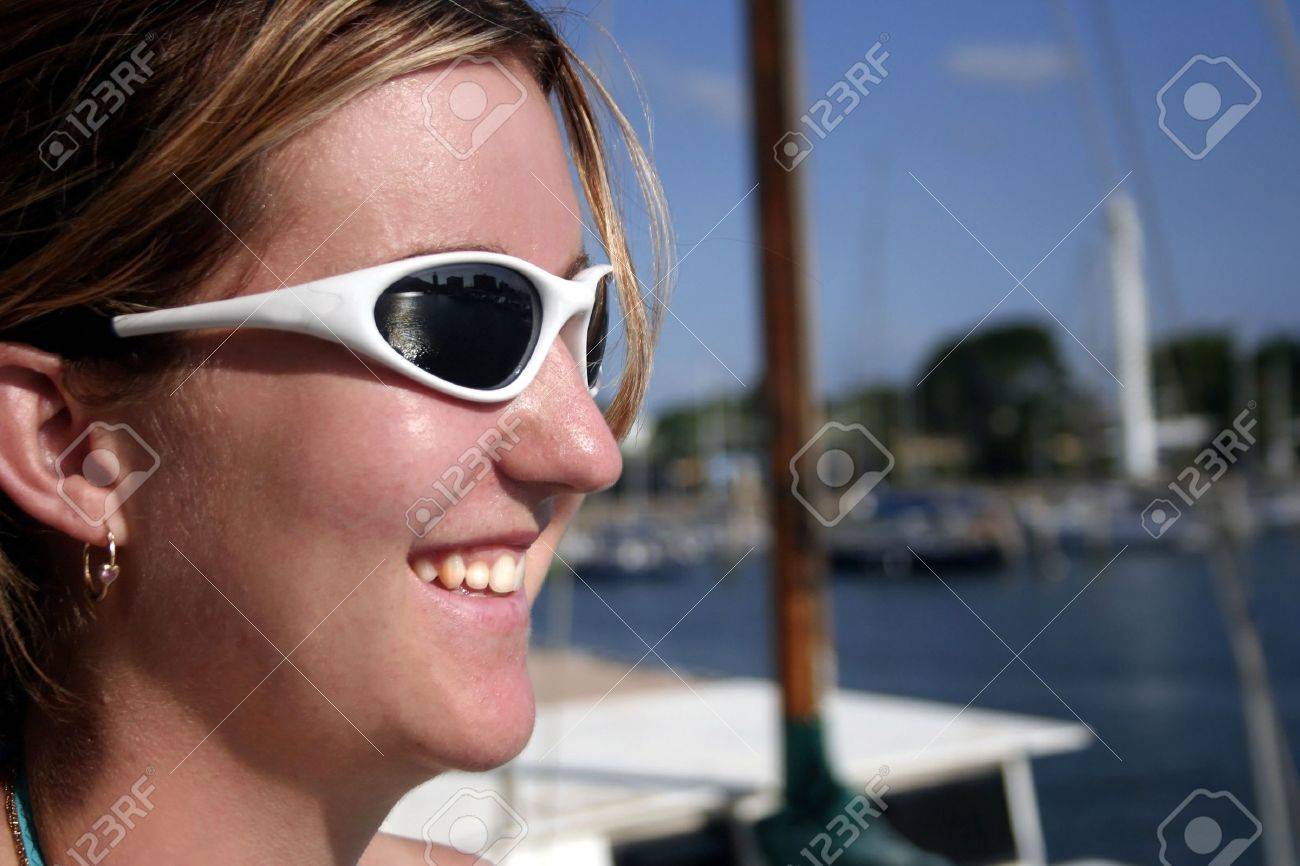 Lunettes de soleil de port de femme à côté de marin de bateau Lunettes de soleil de port de femme à côté de marin de bateau
