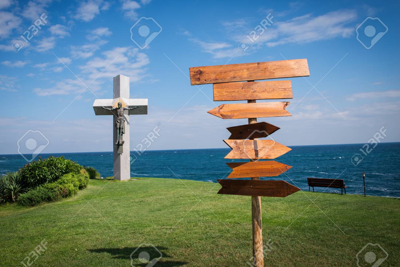 picture of wooden direction signpost in front of the sea stock photo