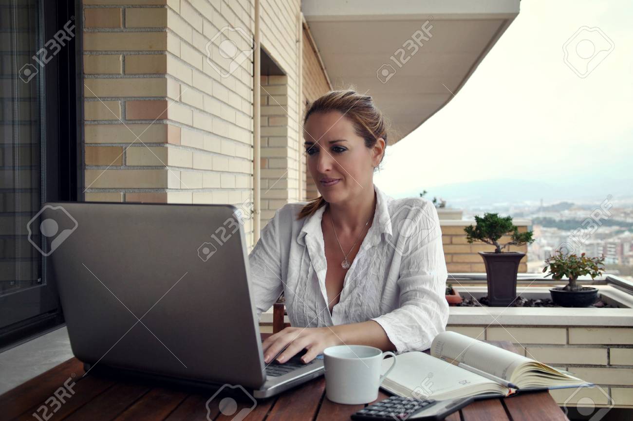 woman working quietly on your terrace with a coffee - 23223405 woman working quietly on your terrace with a coffee - 23223405