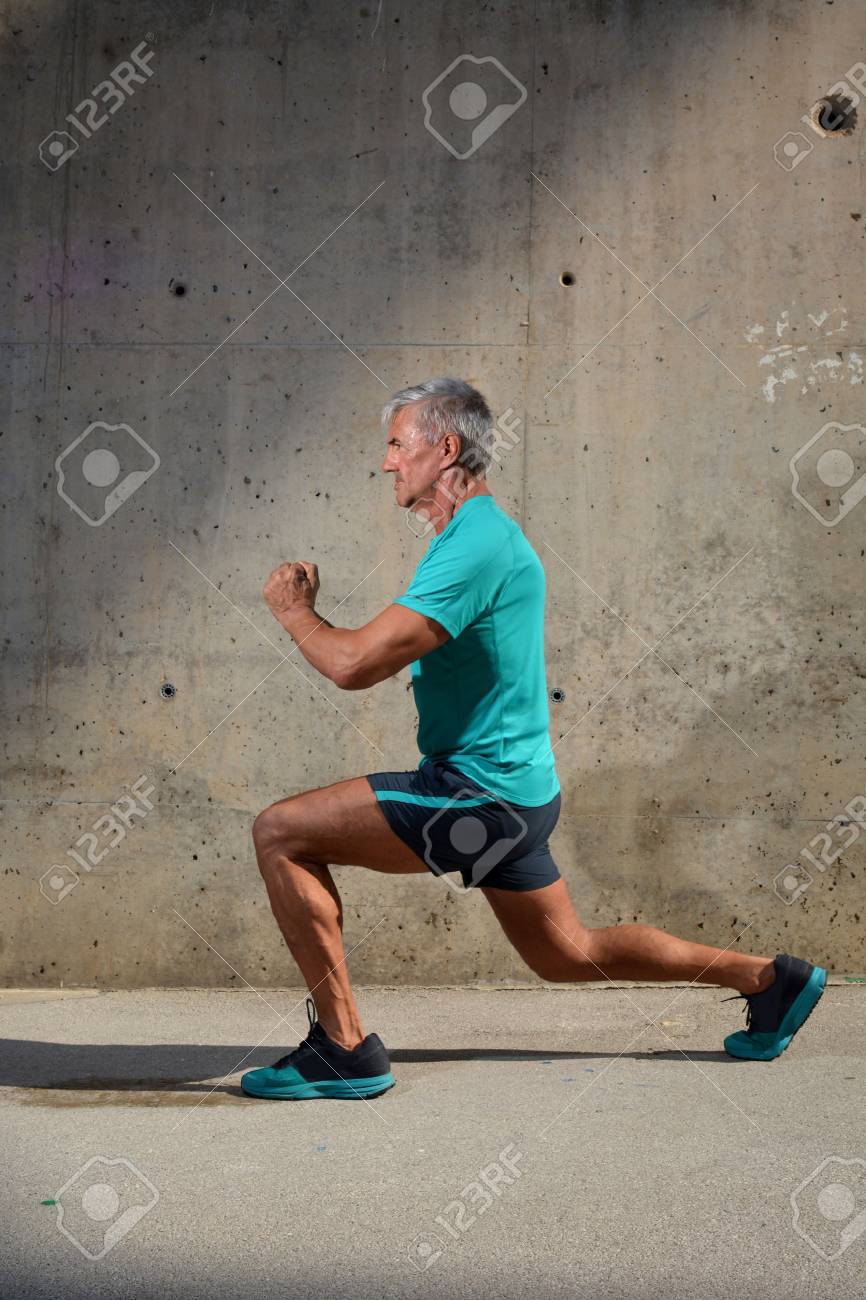 Elderly man practicing sports on the street - 60945103 Elderly man practicing sports on the street - 60945103