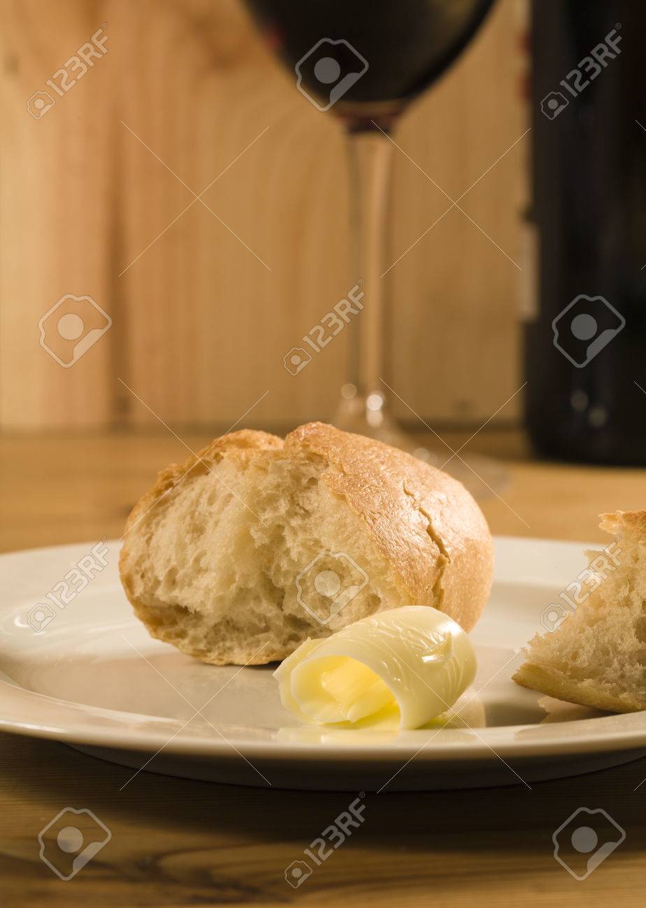 Broken White Bread And Lock Of Butter On White Plate On Wooden Table Glass And Bottle Of Red Wine In Background Stock Photo Picture And Royalty Free Image Image