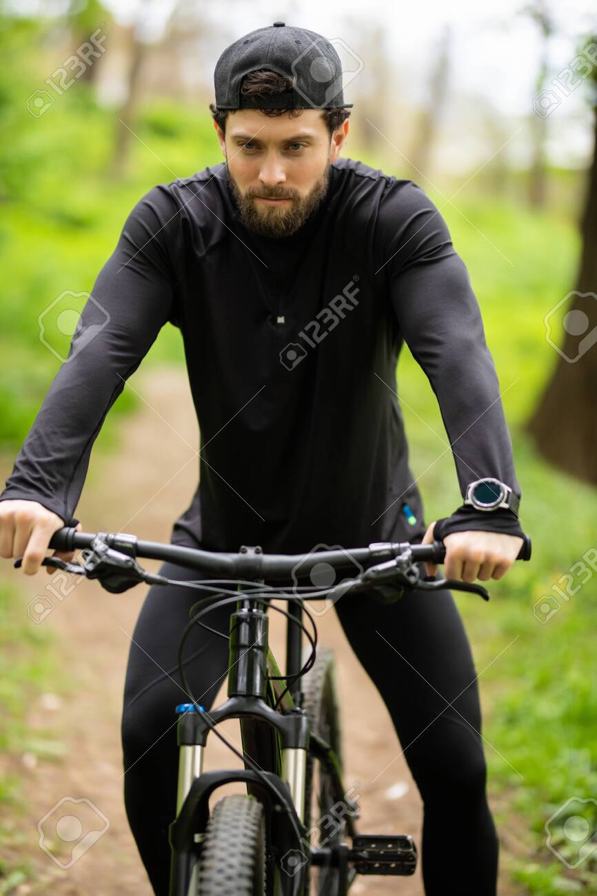 Happy Young man is riding bicycle outside. - 128916680 Happy Young man is riding bicycle outside. - 128916680