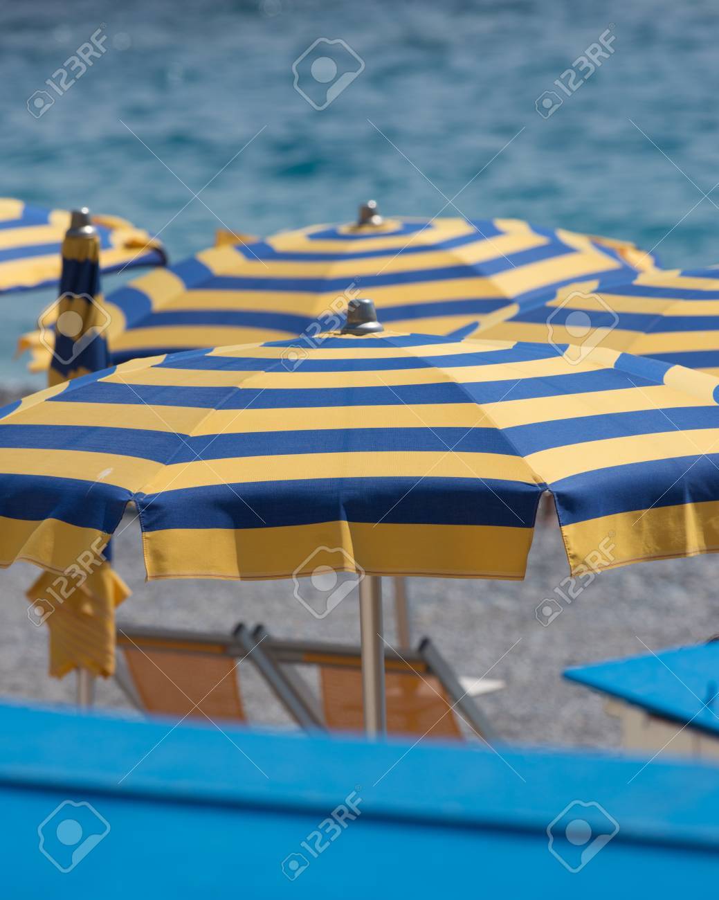 Sombrillas Amarillas Y Azules En La Playa Mediterránea De Noli, Italia Fotos, Imágenes Y Fotografía De Archivo De Derecho. Image 30182497.