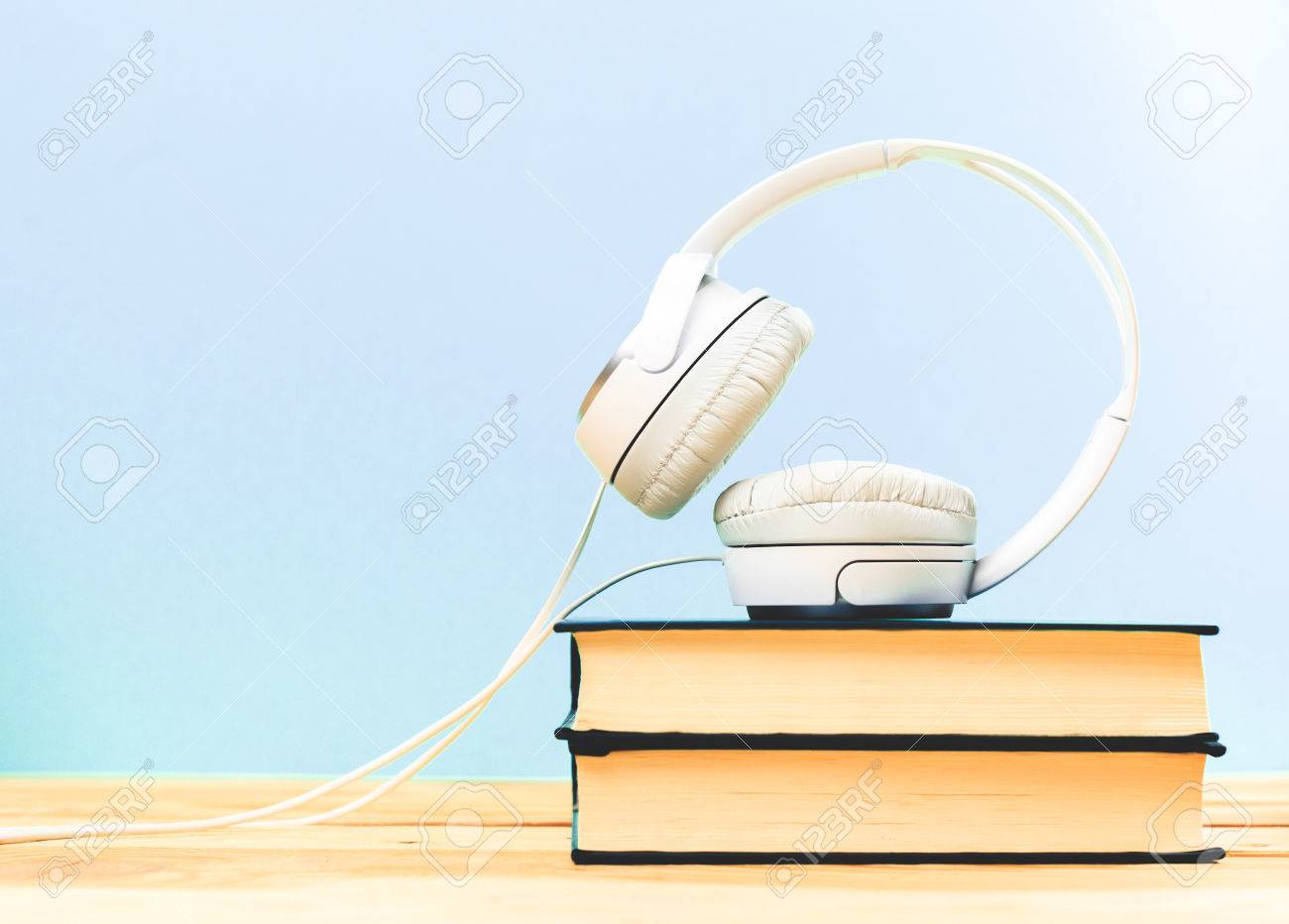 Concept of audiobook. Books on the table with headphones put on them - 76923463 Concept of audiobook. Books on the table with headphones put on them - 76923463