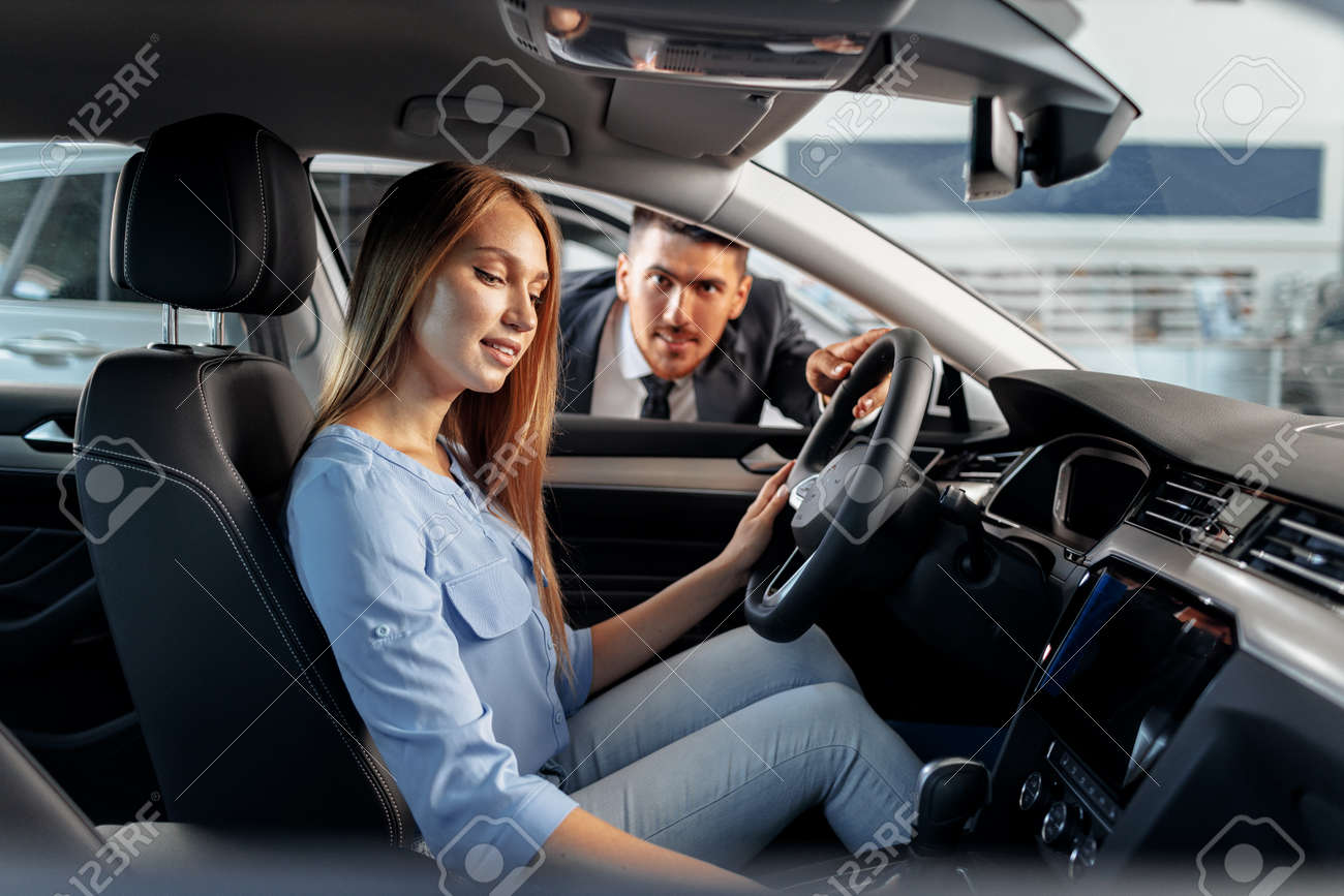 Happy woman new car owner sitting in driver seat - 157209585 Happy woman new car owner sitting in driver seat - 157209585