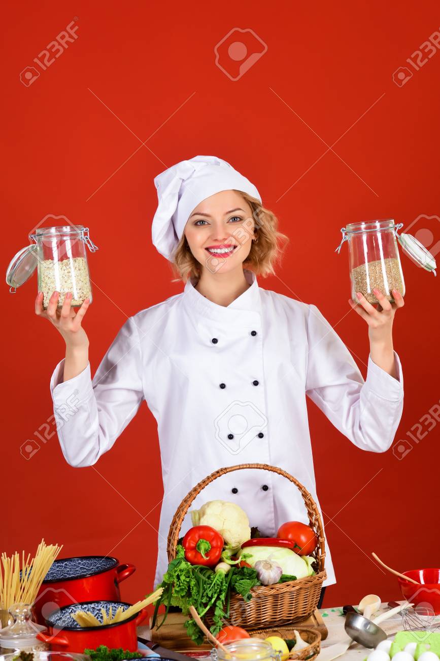professional cook in white suit holding jars with cereal food