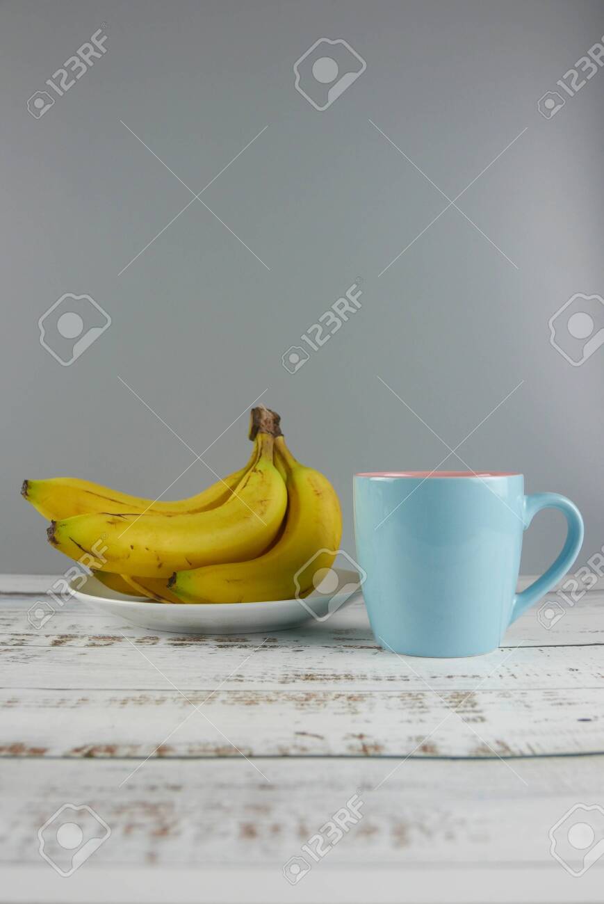 Bunch Of Bananas And A Cup On Wooden Background Copy Space For Stock Photo Picture And Royalty Free Image Image 129915179