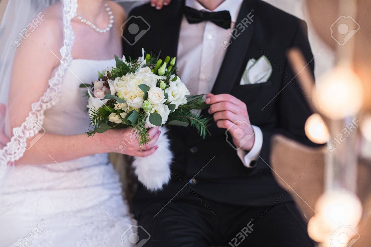 Beautiful winter wedding bouquet. Bridal bouquet with cones, cotton and spruce branches. The bride holds a wedding bouquet next to the groom. - 50241834 Beautiful winter wedding bouquet. Bridal bouquet with cones, cotton and spruce branches. The bride holds a wedding bouquet next to the groom. - 50241834