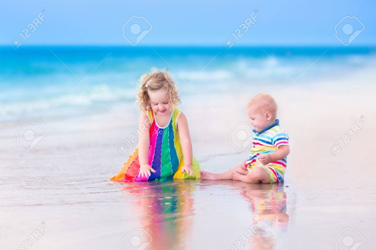 Deux Enfants Heureux Mignon Bouclés Fille De Bébé Et Drôle Petit Garçon Frère Et Soeur Jouer Ensemble à Creuser Le Sable Dans Leau Sur Une Belle