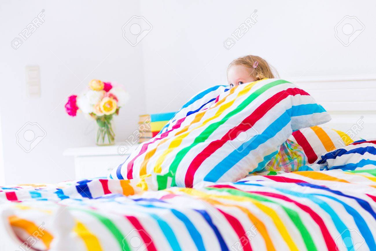 かわいい面白い幼児女の子カラフルな虹と白いベッドに座っている枕とカバー シート皮を再生をストライプ化し 晴れた朝自宅に求める の写真素材 画像素材 Image かわいい面白い幼児女の子カラフルな虹と白いベッドに座っている枕とカバー シート皮を再生をストライプ化し 晴れた朝自宅に求める の写真素材 画像素材 Image