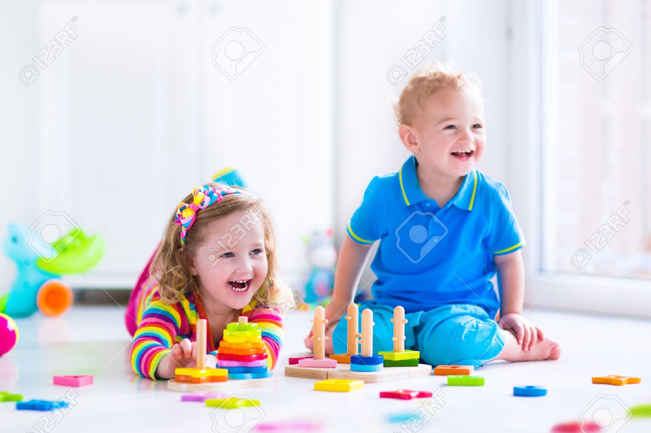 木のおもちゃで遊ぶ子供たち 2 人の子供 かわいい幼児の女の子 面白い男の子は おもちゃ のブロックと自宅の塔を構築またはデイケアで遊んで 保育園と幼稚園の教育子供のおもちゃ の写真素材 画像素材 Image