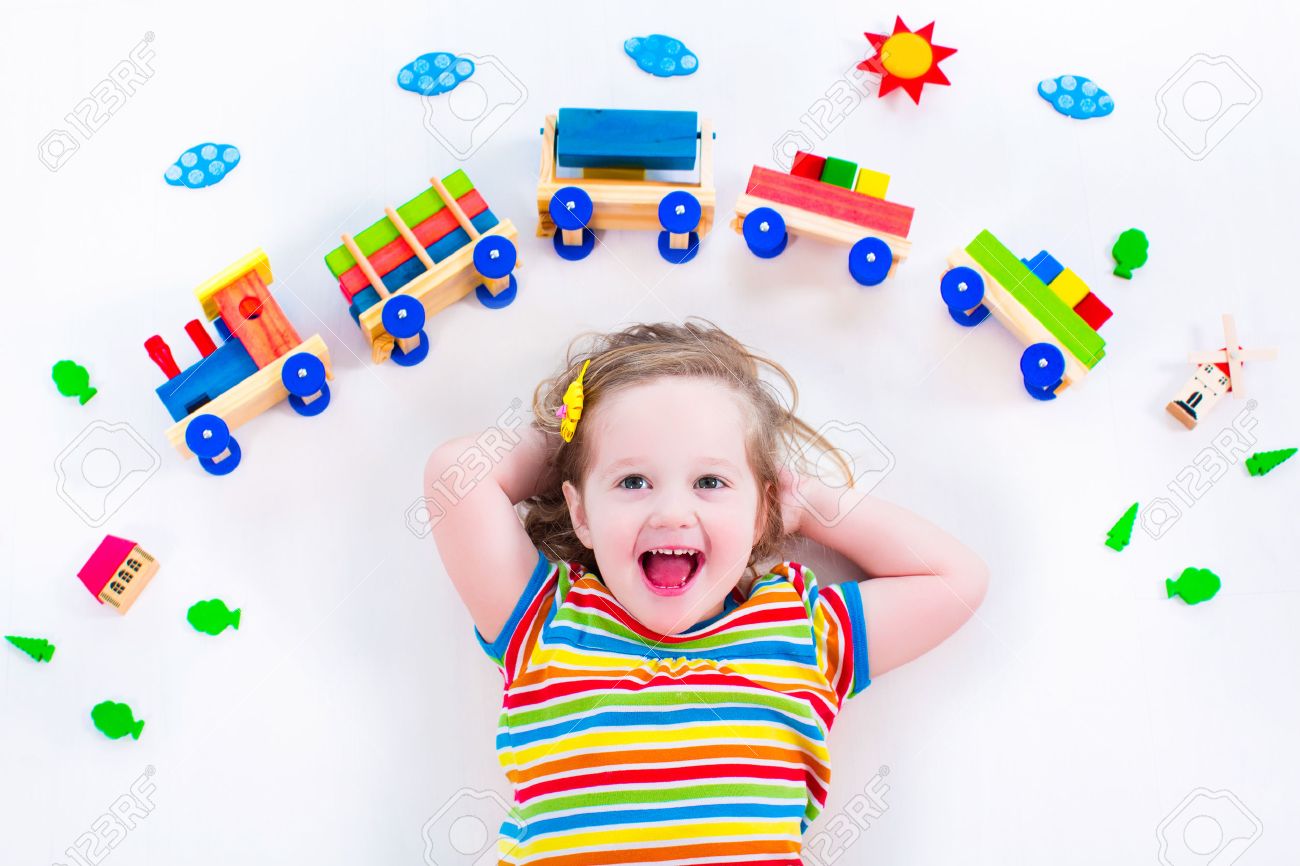 Child playing with wooden train. Toy railroad for kids. Toddler kid at day care. Educational toys for preschool and kindergarten child. Little girl at daycare. - 40446185 Child playing with wooden train. Toy railroad for kids. Toddler kid at day care. Educational toys for preschool and kindergarten child. Little girl at daycare. - 40446185