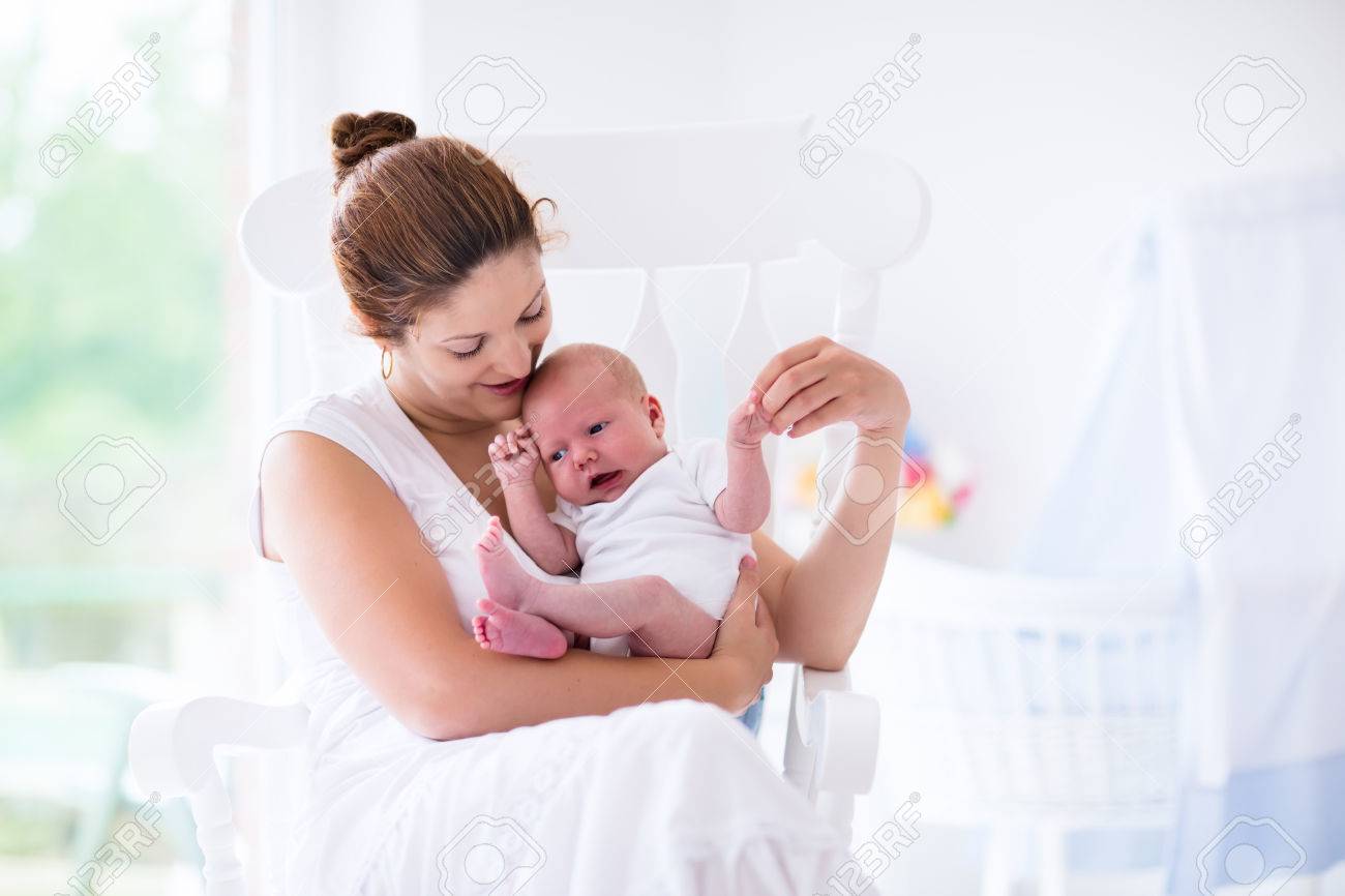 Jeune Mere Tenant Son Enfant Nouveau Ne Soins Infirmiers Maman Bebe Femme Et Le Nouveau Garcon Ne Detendre Dans Une Chambre Blanche Avec Chaise Bercante Et Berceau Bleu Nursery Interieur Mere Bebe De Jeune Mere Tenant Son Enfant Nouveau Ne Soins Infirmiers Maman Bebe Femme Et Le Nouveau Garcon Ne Detendre Dans Une Chambre Blanche Avec Chaise Bercante Et Berceau Bleu Nursery Interieur Mere Bebe De