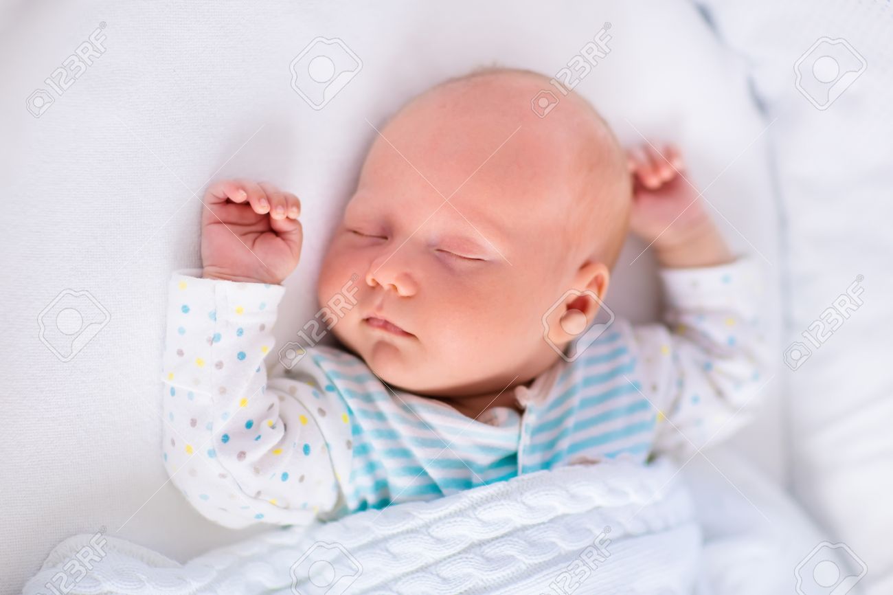 newborn baby boy in bed new born child sleeping under a white