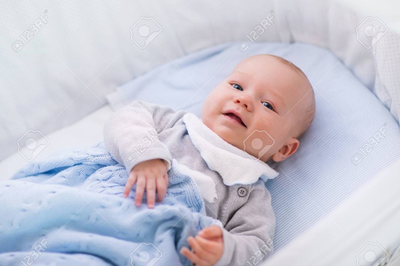 newborn baby boy in bed new born child sleeping under a white