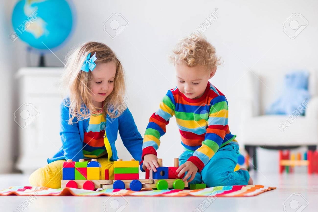 Children playing with wooden train. Toddler kid and baby play with blocks, trains and cars. Educational toys for preschool and kindergarten child. Boy and girl build toy railroad at home or daycare. - 54639007 Children playing with wooden train. Toddler kid and baby play with blocks, trains and cars. Educational toys for preschool and kindergarten child. Boy and girl build toy railroad at home or daycare. - 54639007
