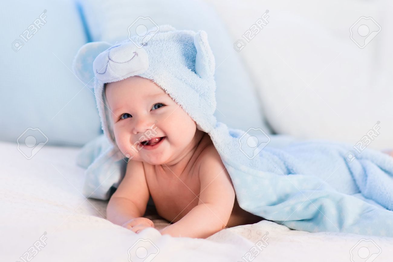 Neonato che porta pannolini e asciugamano blu in bianco soleggiata ... Vasca per doccia bambini