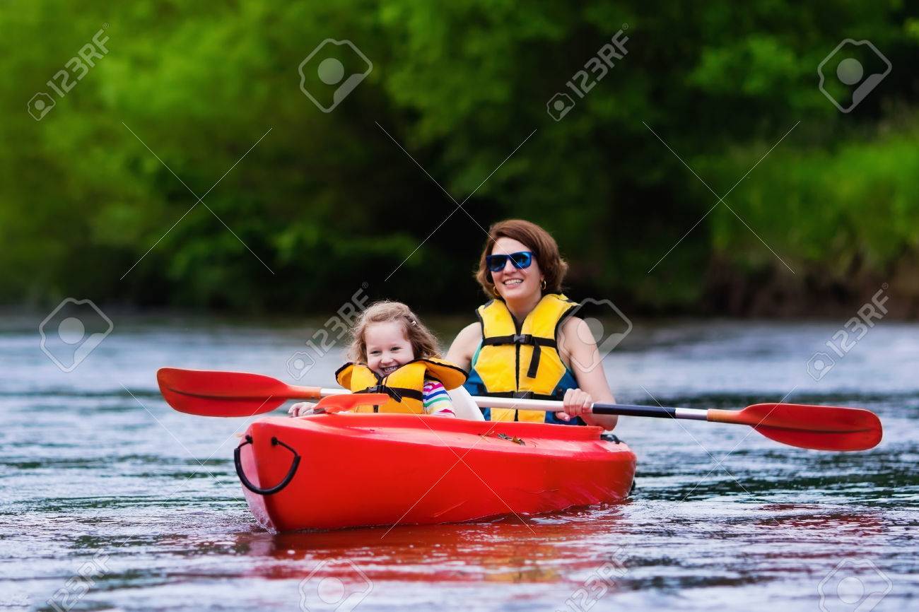 family on kayaks and canoe tour mother and child paddling in