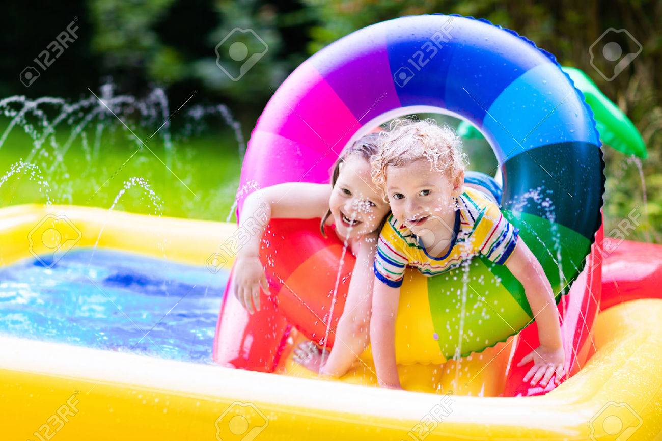 Children playing in inflatable baby pool. Kids swim and splash in colorful garden play center. Happy boy and girl playing with water toys on hot summer day. Family having fun outdoors in the backyard. - 59197374 Children playing in inflatable baby pool. Kids swim and splash in colorful garden play center. Happy boy and girl playing with water toys on hot summer day. Family having fun outdoors in the backyard. - 59197374