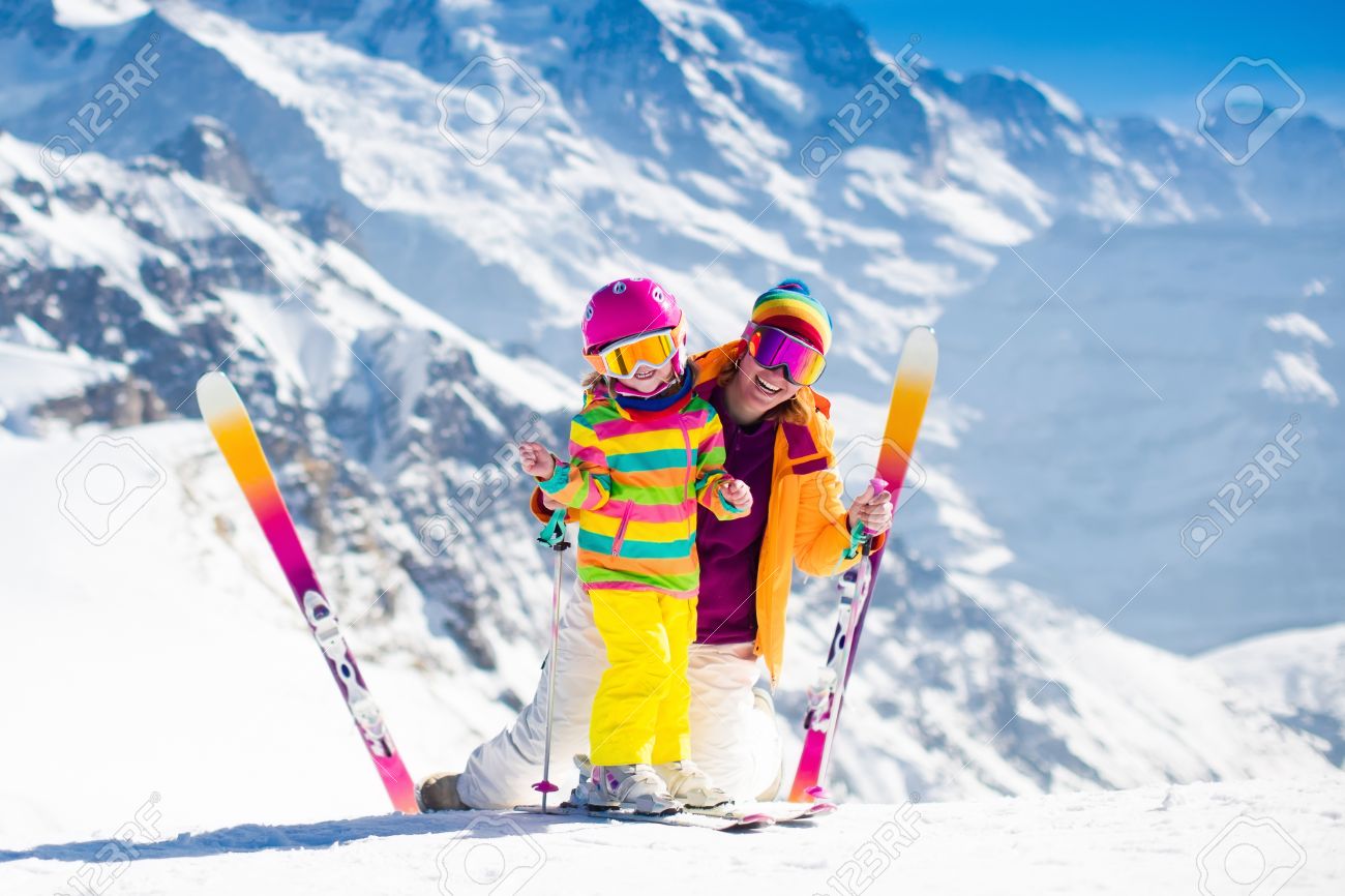 Family ski vacation. Group of skiers in Swiss Alps mountains. Mother and child skiing in winter. Parents teach kids alpine downhill skiing. Ski gear and wear, safe helmets. - 63589457 Family ski vacation. Group of skiers in Swiss Alps mountains. Mother and child skiing in winter. Parents teach kids alpine downhill skiing. Ski gear and wear, safe helmets. - 63589457