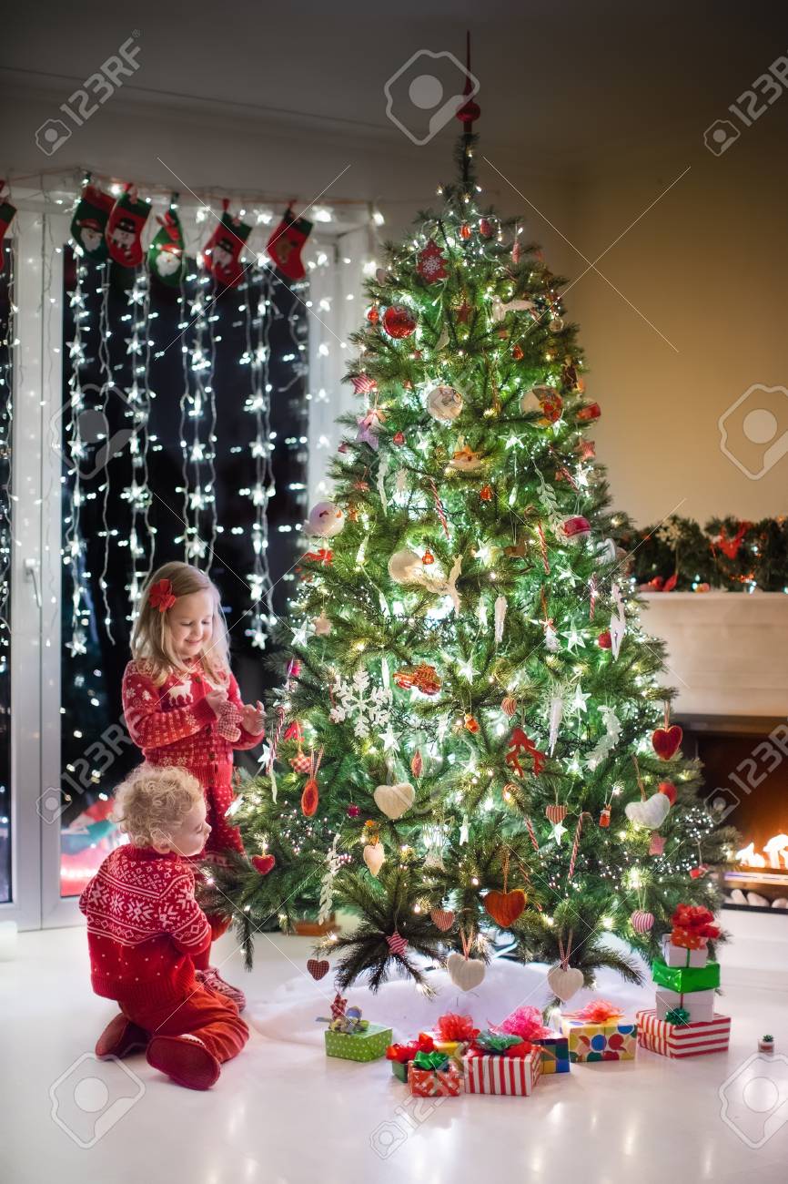 Bimbi Che Aprono I Regali Di Natale.Immagini Stock Felice Piu Piccoli In Corrispondenza Maglioni Rossi Maglia Decorare L Albero Di Natale In Bel Soggiorno Con Camino Tradizionale Bambini Che Aprono I Regali La Vigilia Di Natale Image 64640618
