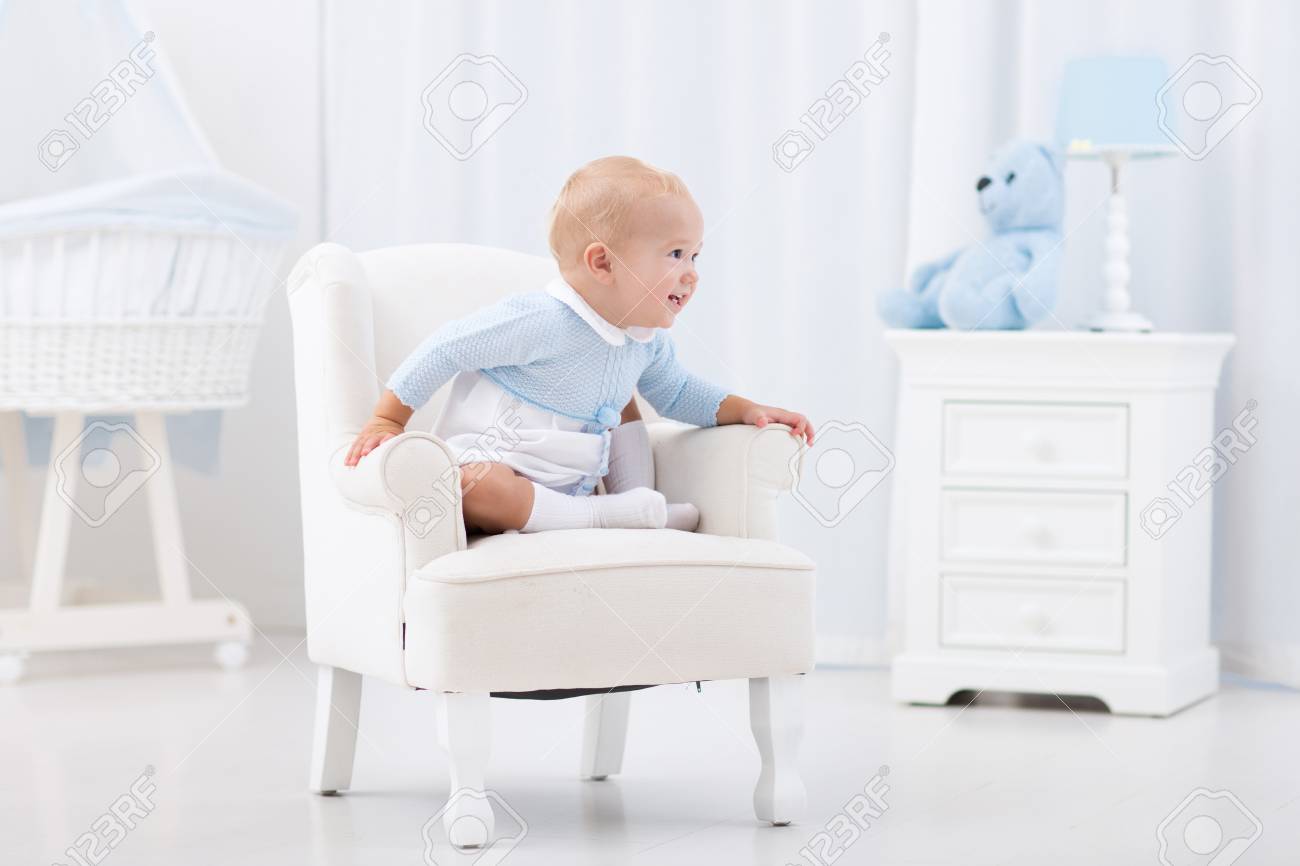 Bebé Adorable Que Juega En Blanco Soleado Niño Feliz Que Se Relaja En Silla De Juguete En La De Juego. Guardería Y Sala Juegos Para Los Niños Pequeños. Muebles