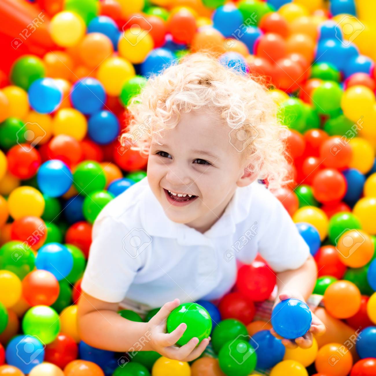 子供遊園地 屋内のプレイ センターで誕生日パーティーにボールをピットで楽しんで幸せな笑い少年 カラフルなボールが遊び場のボールプールで遊ぶ子 小さな子供のおもちゃで活動 の写真素材 画像素材 Image