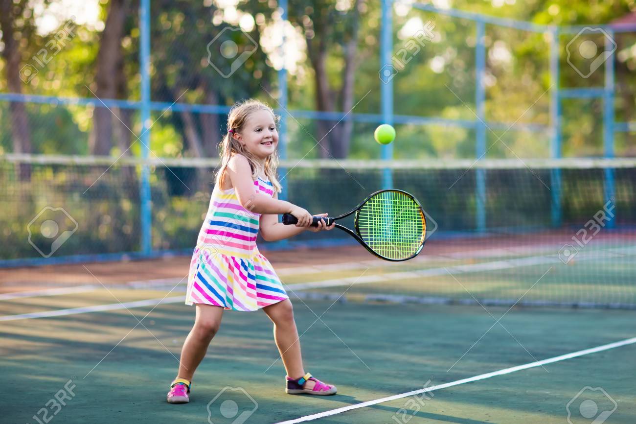 L'enfant Joue Au Tennis Sur Le Terrain Extérieur. Petite Fille Avec  Raquette De Tennis Et Balle Dans Le Club De Sport. Exercice Actif Pour Les  Enfants. Activités D'été Pour Enfants. Formation Pour