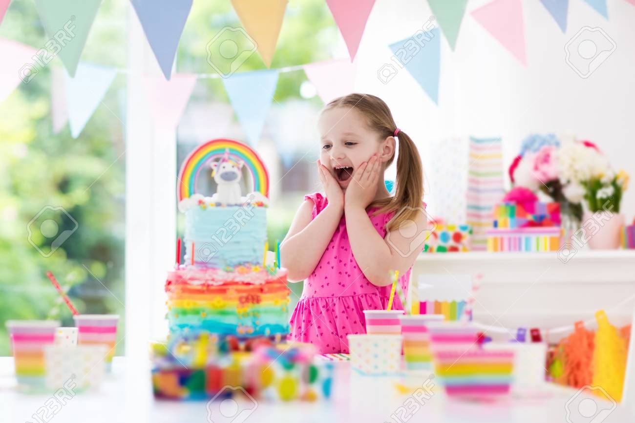 Fete D Anniversaire Pour Enfants Avec Une Decoration Pastel Coloree Et Un Gateau Arc En Ciel De Licorne Petite Fille Avec Des Bonbons Des Bonbons Et Des Fruits Ballons Et Banniere A La Table Decoree