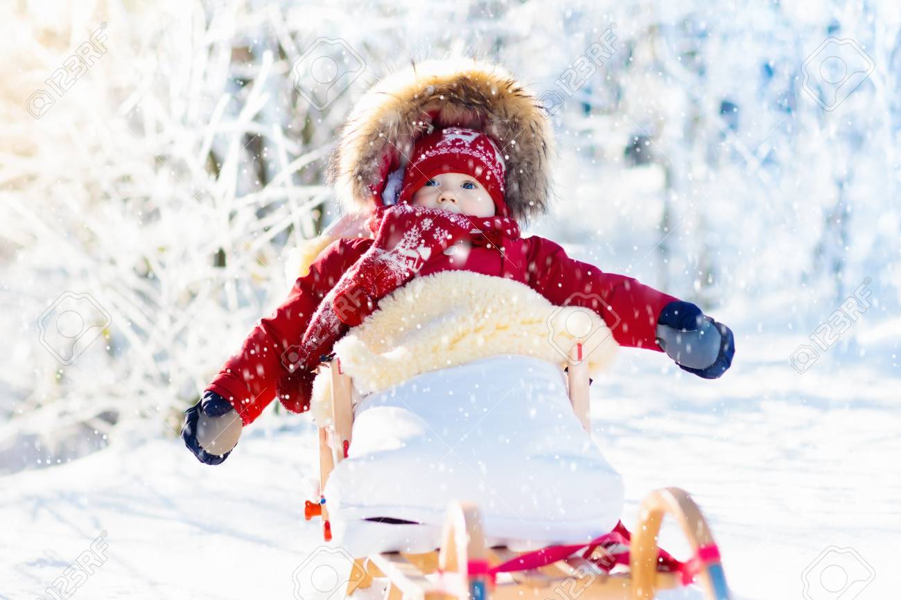 Luge Et Neige Amusante Pour Les Enfants Bebe Luge Dans Le Parc D Hiver Enneige Petit Garcon En Veste Rouge Chaud Et Bonnet Tricote En Chanceliere En Peau De Mouton Kid Sur Traineau