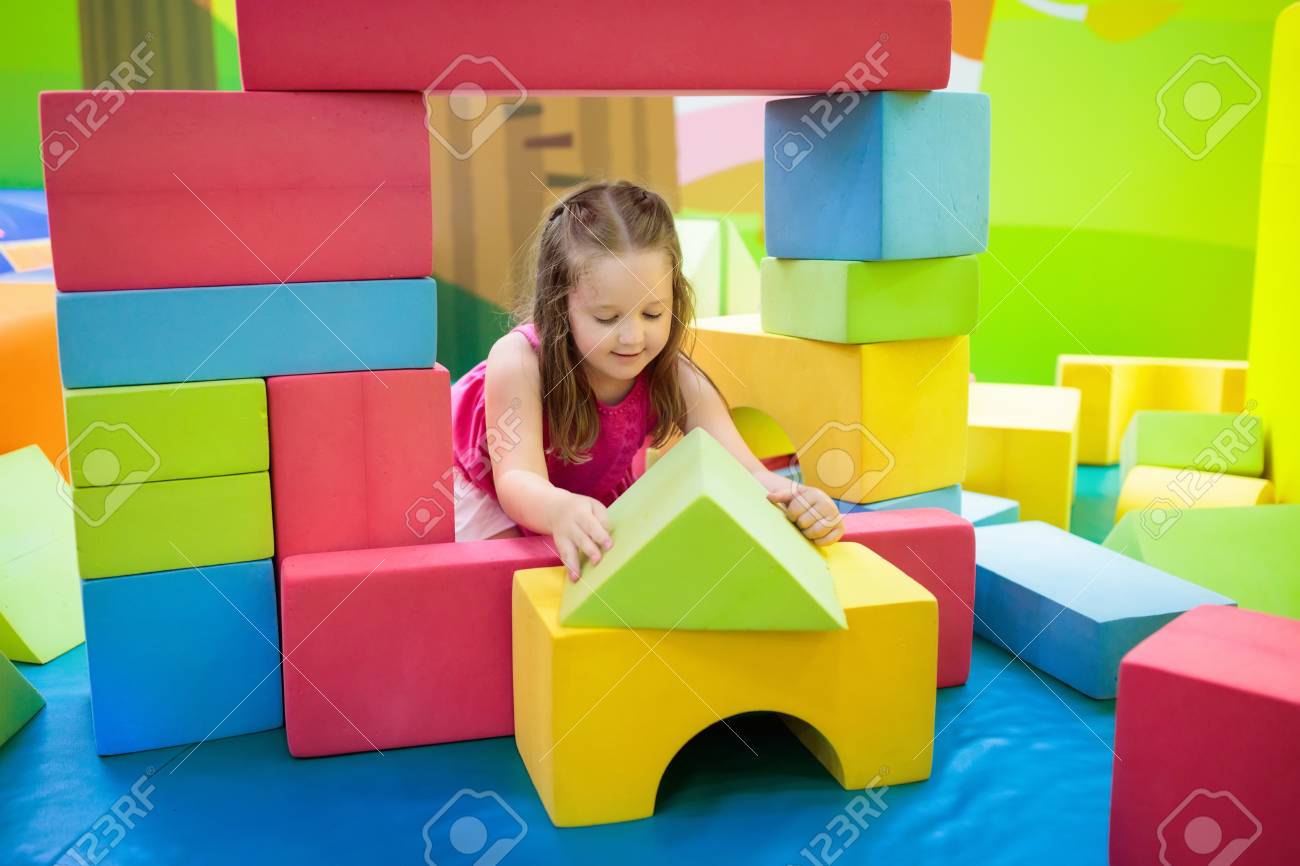 カラフルな建設おもちゃのブロックで遊ぶ子供 若い子供のための教育玩具 幼稚園や幼稚園のプレイルーム デイケアの遊び場で幼児の子供 保育園でブロック付きの女の子の建物の家 の写真素材 画像素材 Image