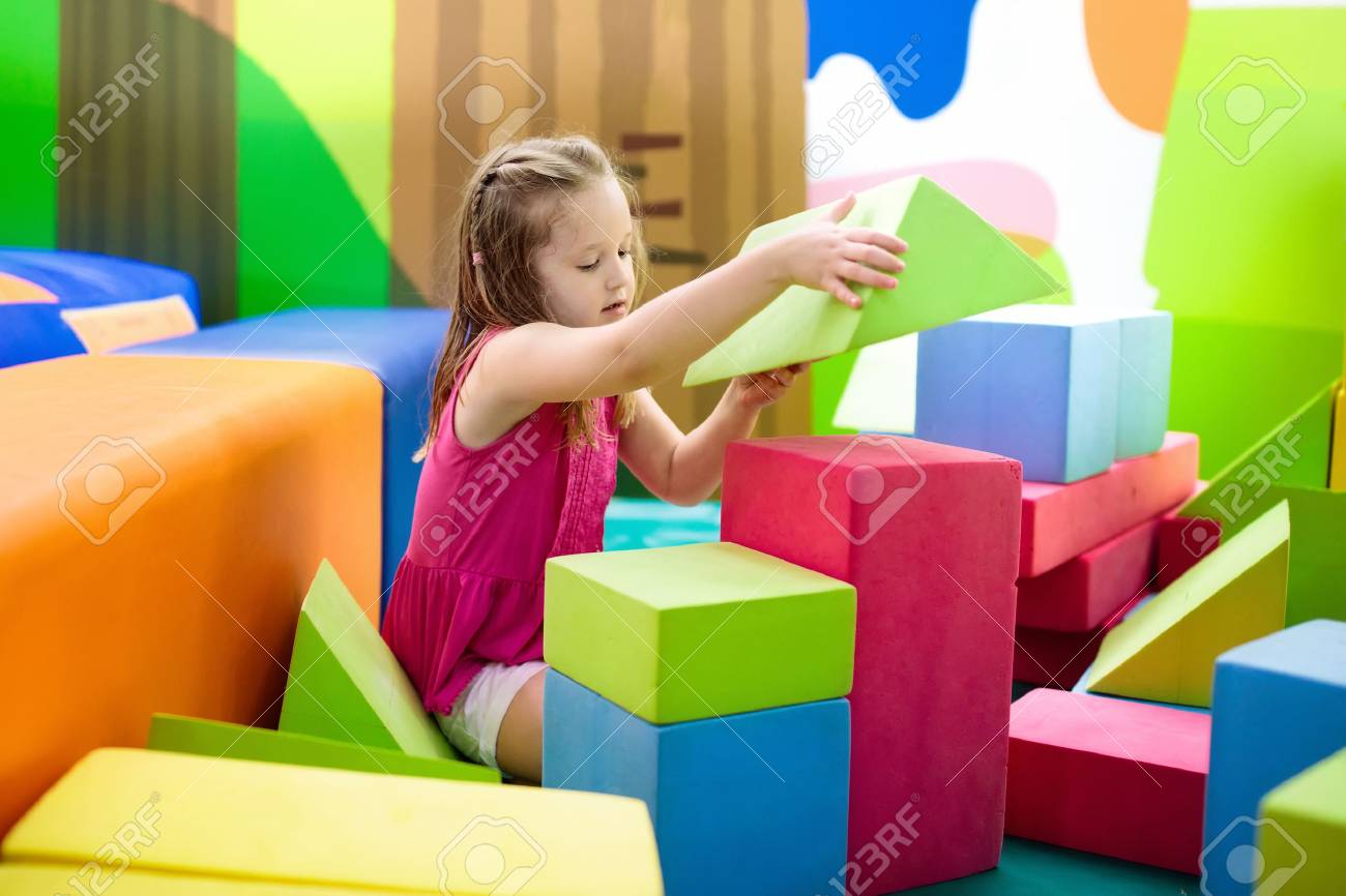 カラフルな建設おもちゃのブロックで遊ぶ子供 若い子供のための教育玩具 幼稚園や幼稚園のプレイルーム デイケアの遊び場で幼児の子供 保育園でブロック付きの女の子の建物の家 の写真素材 画像素材 Image
