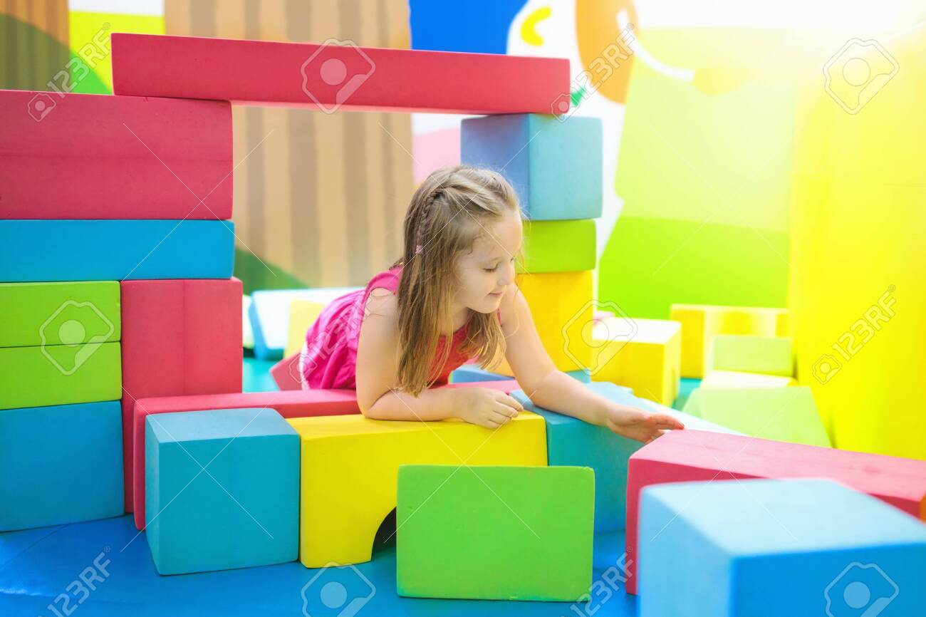カラフルな建設おもちゃのブロックで遊ぶ子供 若い子供のための教育玩具 幼稚園や幼稚園のプレイルーム デイケアの遊び場で幼児の子供 保育園でブロック付きの女の子の建物の家 の写真素材 画像素材 Image