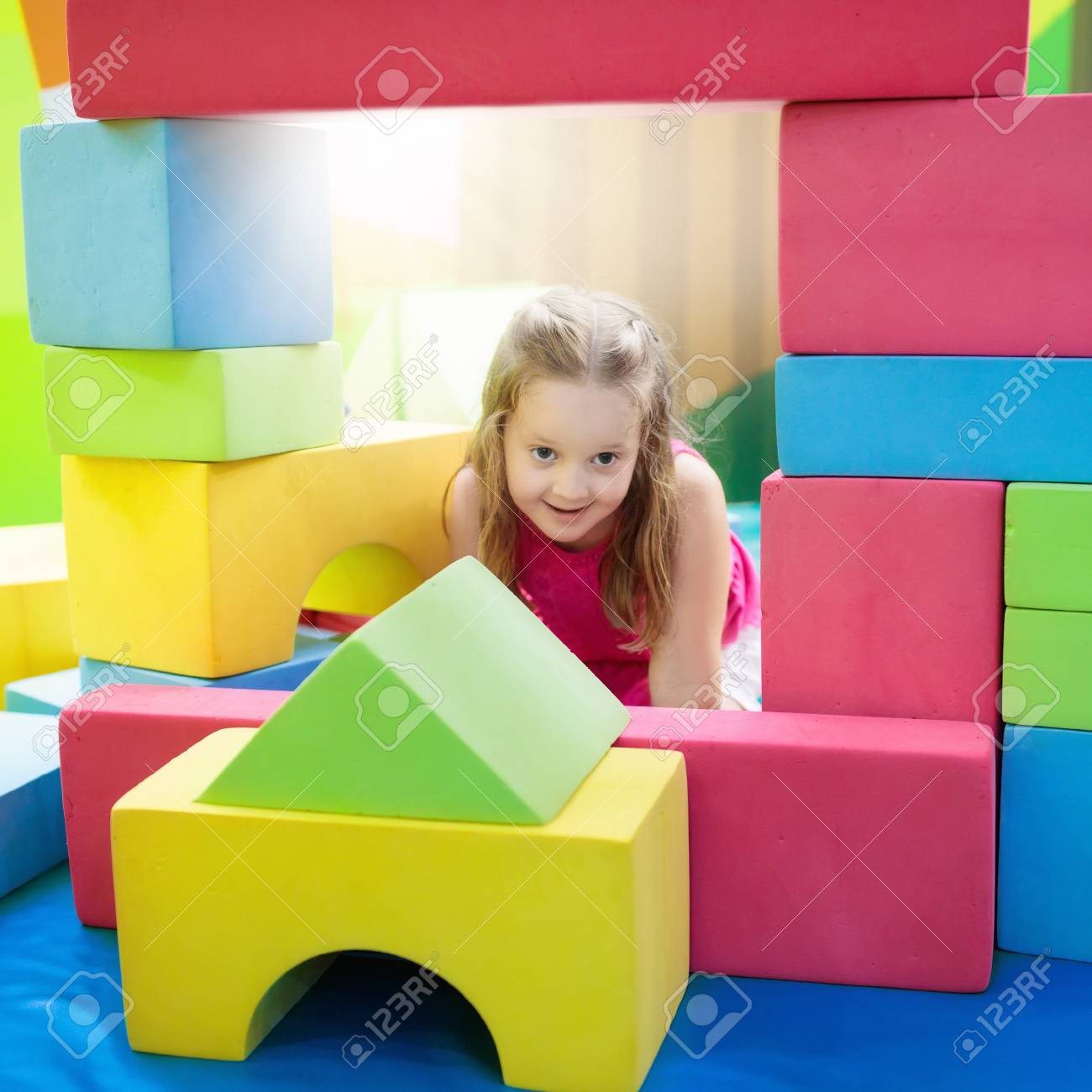 カラフルな建設おもちゃのブロックで遊ぶ子供 若い子供のための教育玩具 幼稚園または就学前のプレイルーム デイケアの遊び場で幼児の子供 保育園でブロック付きの女の子の建物の家 の写真素材 画像素材 Image