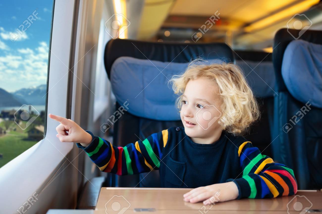 電車で旅行する子供 ヨーロッパの家族の休暇に高速急行列車の小さな子供 鉄道で旅行 鉄道車両の子供たち レールウェイワゴンの子供たち 若い乗客のためのエンターテイメント の写真素材 画像素材 Image