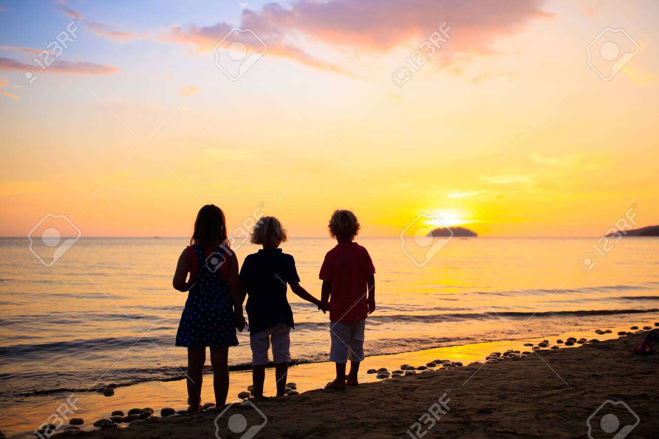 Child playing on ocean beach. Kid jumping in the waves at sunset. Sea vacation for family with kids. Summer island during summer holiday - 123776197 Child playing on ocean beach. Kid jumping in the waves at sunset. Sea vacation for family with kids. Summer island during summer holiday - 123776197