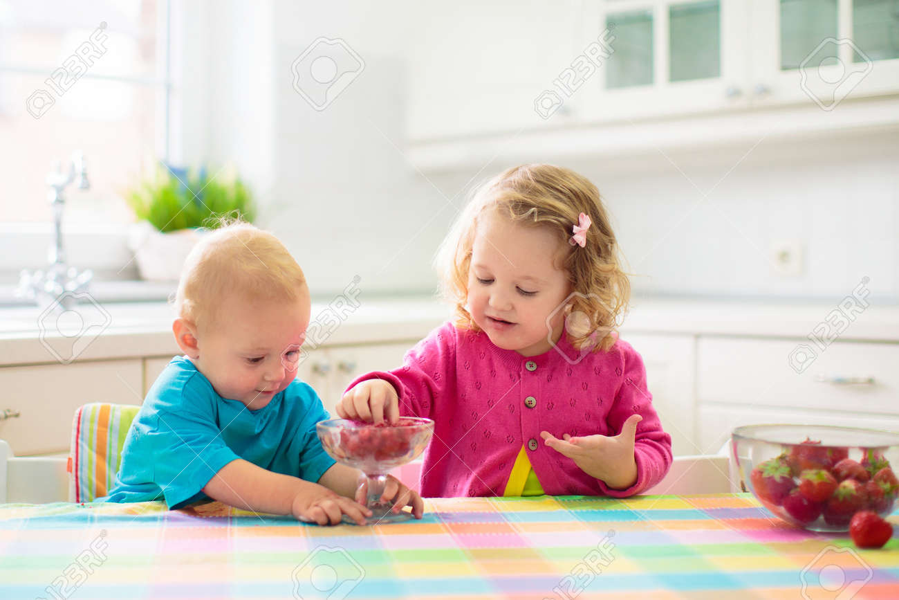 Child having breakfast. Kid drinking milk and eating cereal with fruit. Little boy and girl at white dining table in kitchen at window. Kids eat on sunny morning. Healthy balanced nutrition for kids. - 168267806 Child having breakfast. Kid drinking milk and eating cereal with fruit. Little boy and girl at white dining table in kitchen at window. Kids eat on sunny morning. Healthy balanced nutrition for kids. - 168267806