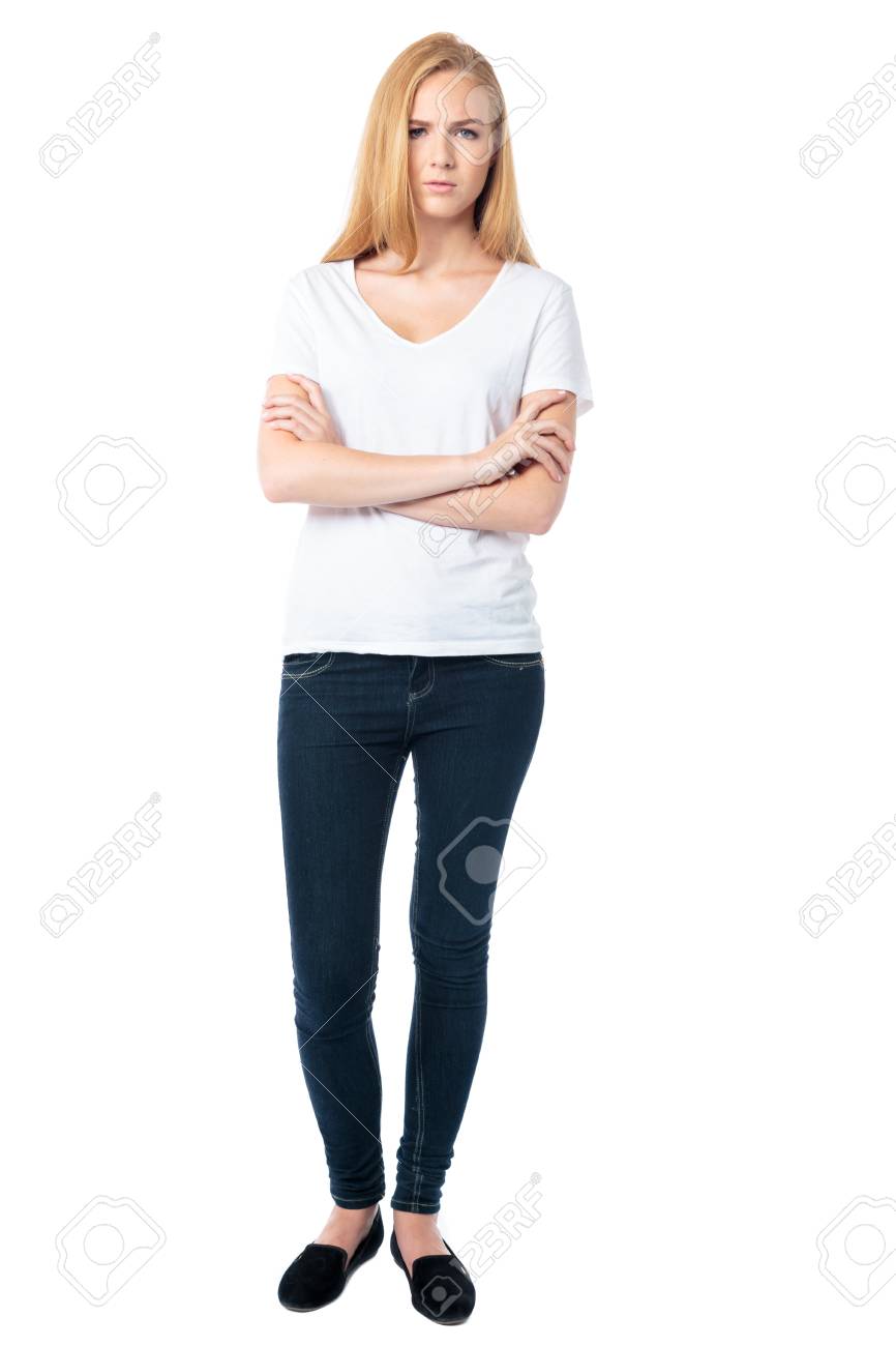 長いブロンドの髪に立って彼女の腕とカメラに直面して自信を持って深刻な若い女性は 白の完全な長さを交差 の写真素材 画像素材 Image