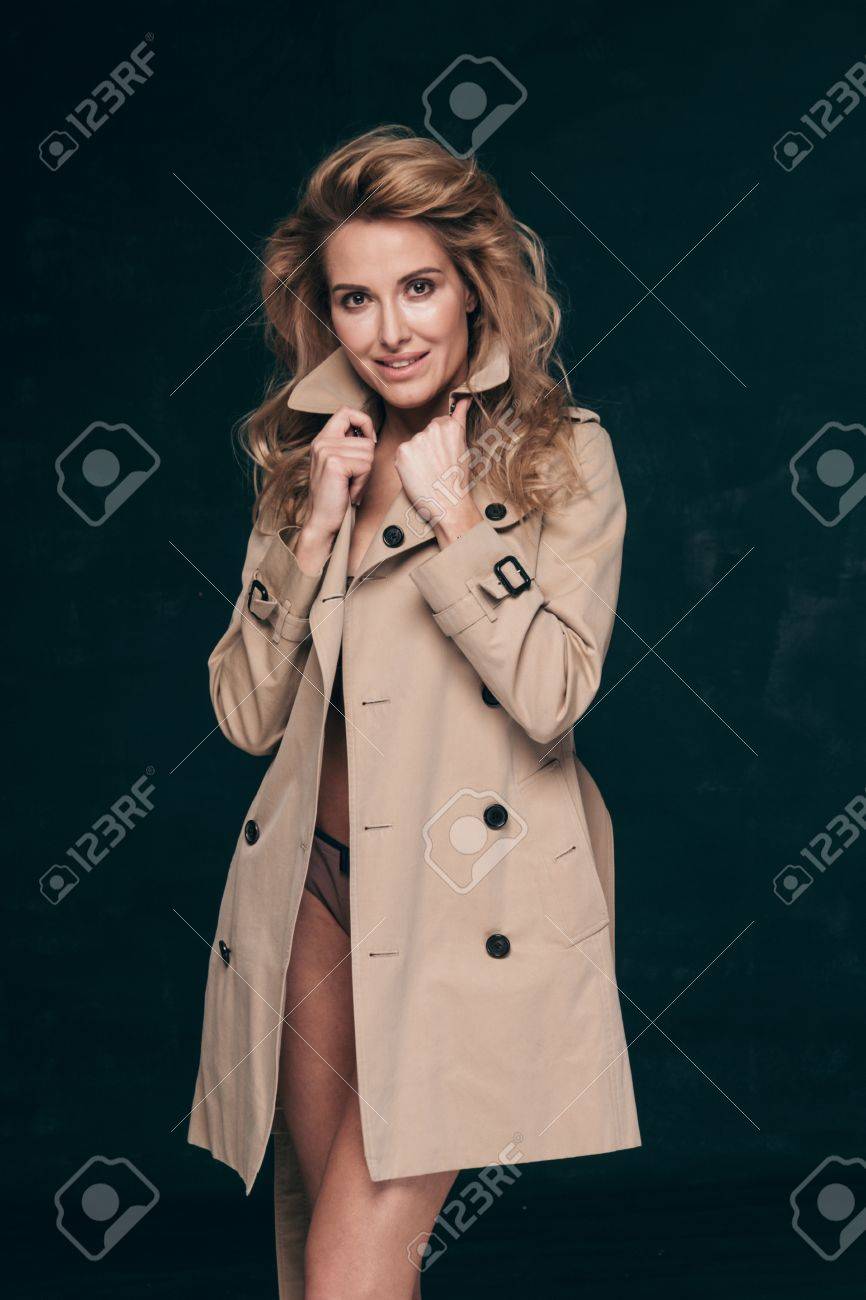 Tiro De Alta Costura De Mujer Rubia Con El Pelo Rizado En La Chaqueta Y La Elegante Lencería Elegante Posando Sobre Fondo Oscuro Estudio. Fotos, Retratos, Imágenes Y Fotografía De Libres