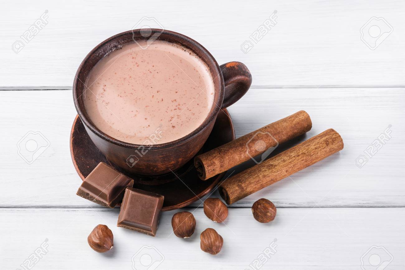 壊れたチョコレート キューブ ヘーゼル ナッツとシナモンスティックを白い木製の板に茶色の粘土のカップに牛乳とココア の写真素材 画像素材 Image 8681