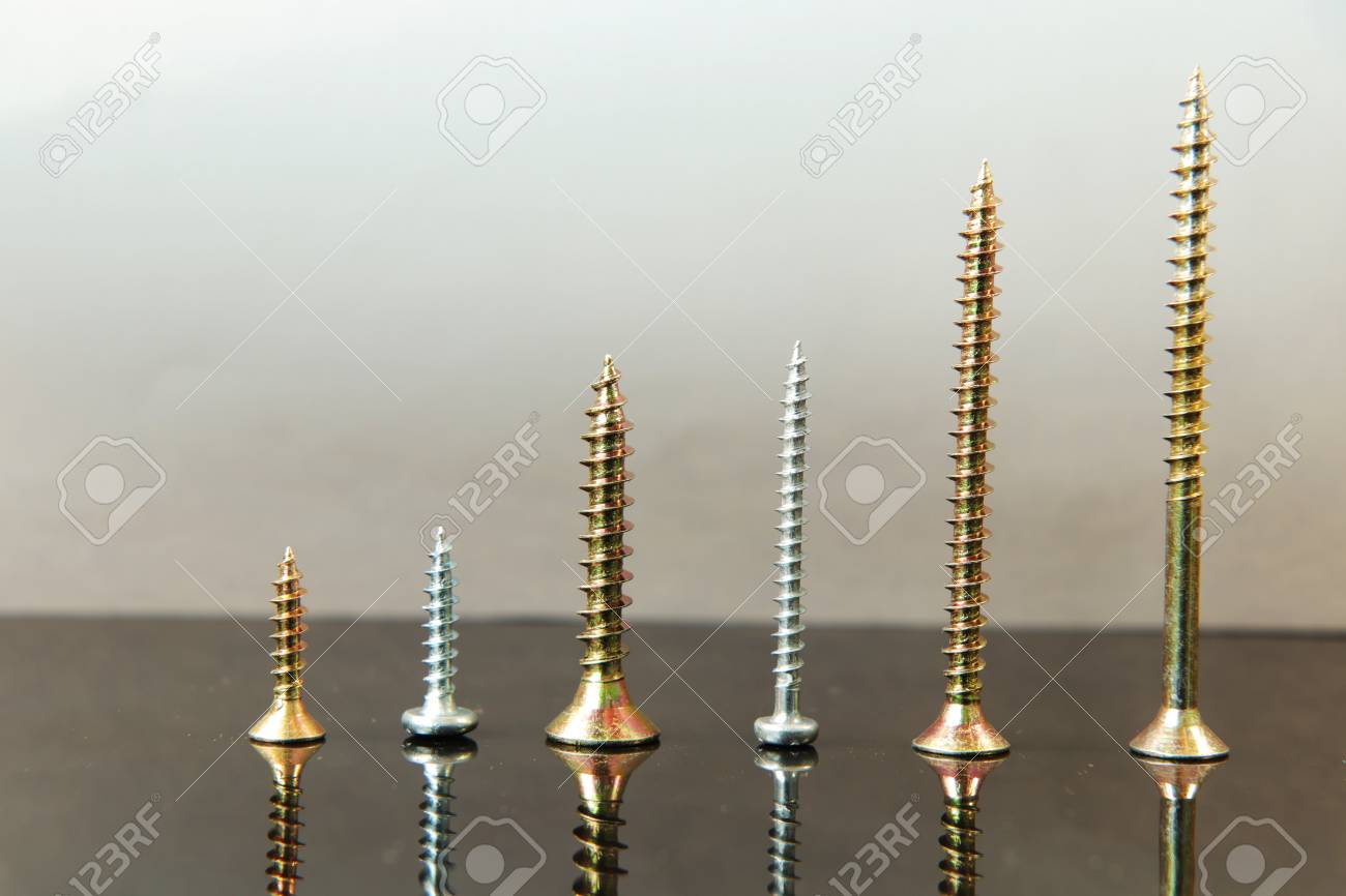 a many silver and golden nails put together in ascending order on