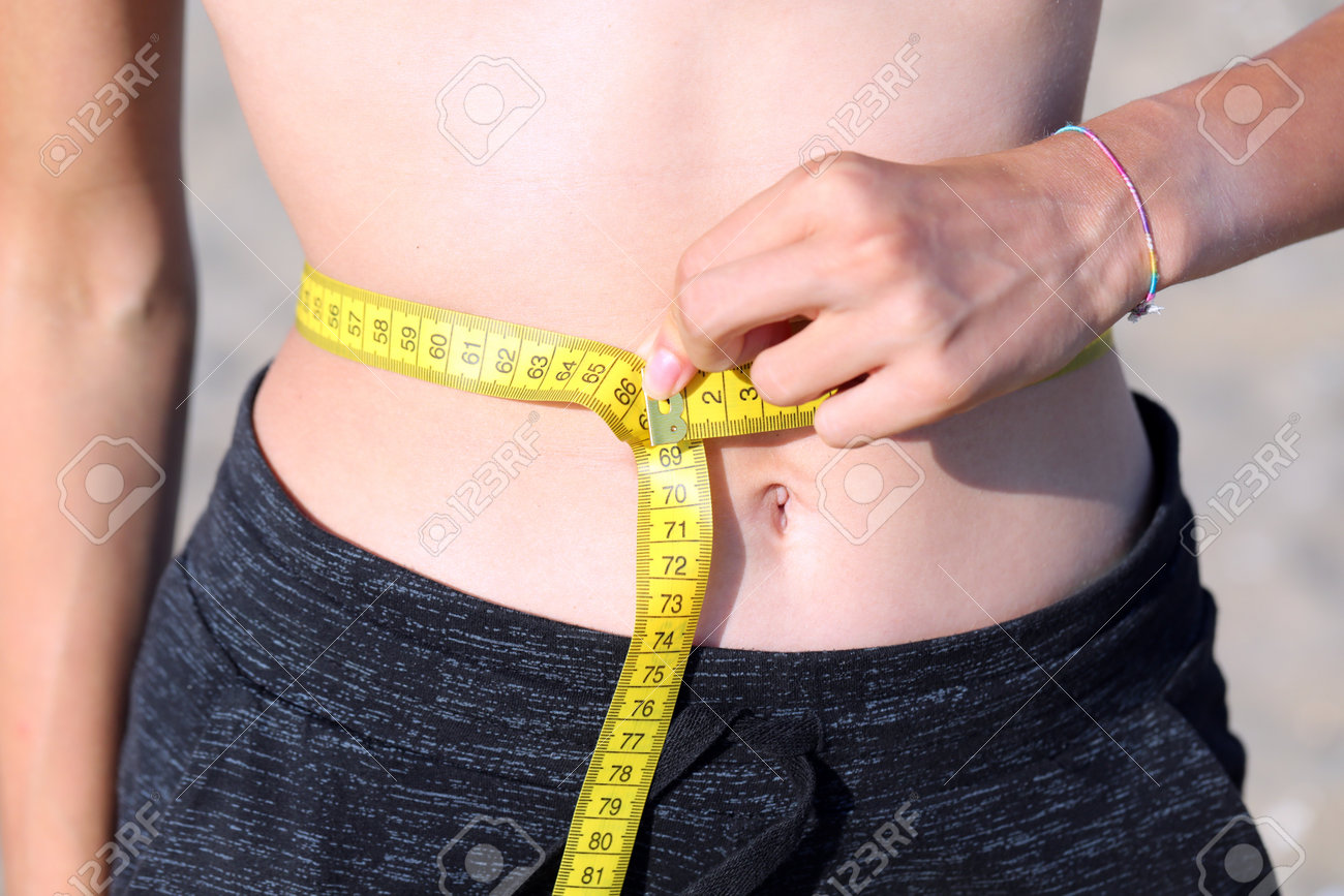 ウエスト測定 巻尺とセンチメートル単位の若い女の子の腹のウエスト測定の写真素材・画像素材 Image 196859242