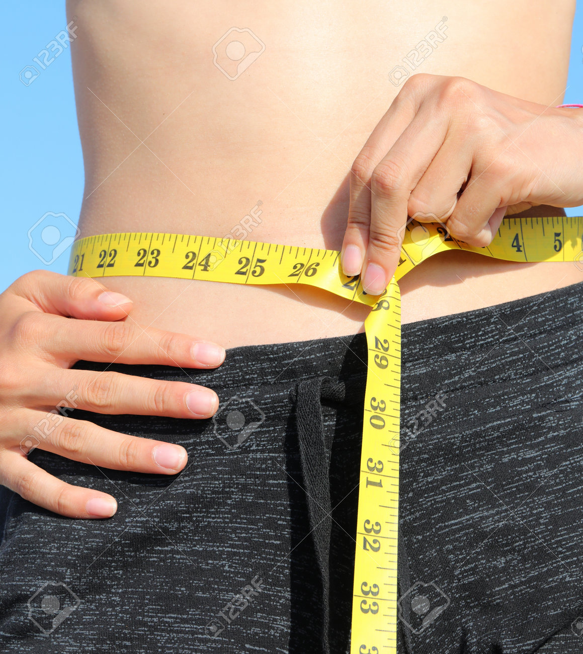 ウエスト測定 黄色い巻尺とインチ測定による若い女の子の腹のウエスト測定の写真素材・画像素材 Image 196859523