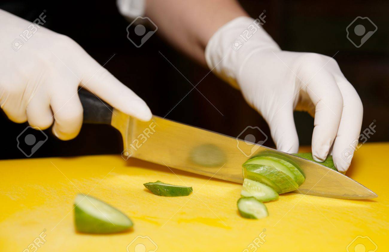 Chef is cutting cucumber on yellow plank - 13965484 Chef is cutting cucumber on yellow plank - 13965484