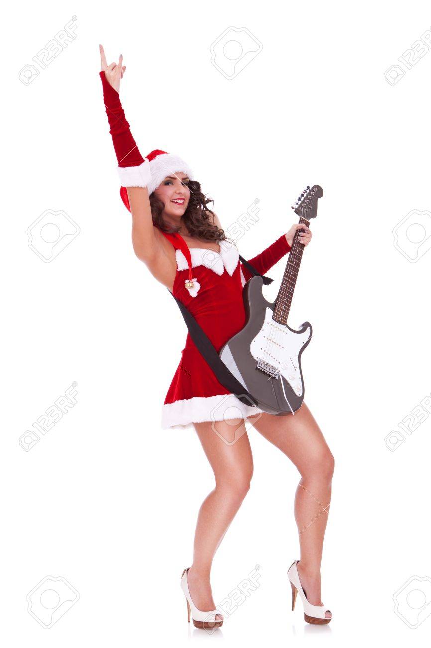セクシーな若いサンタ女性 ギターを演奏しロッカー ジェスチャーを作るホワイト バック グラウンド の写真素材 画像素材 Image