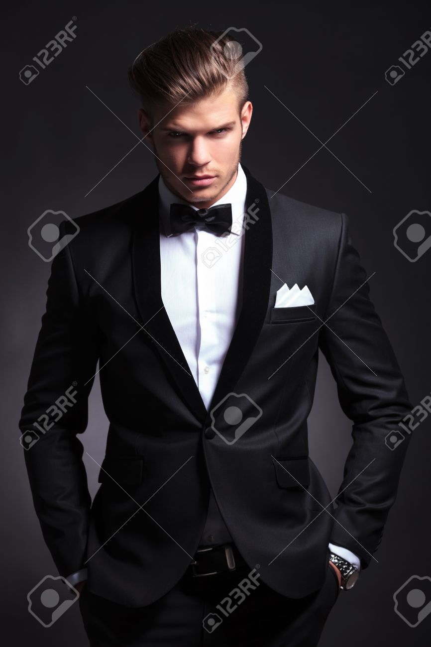 elegante hombre de moda joven en el smoking es la celebración de