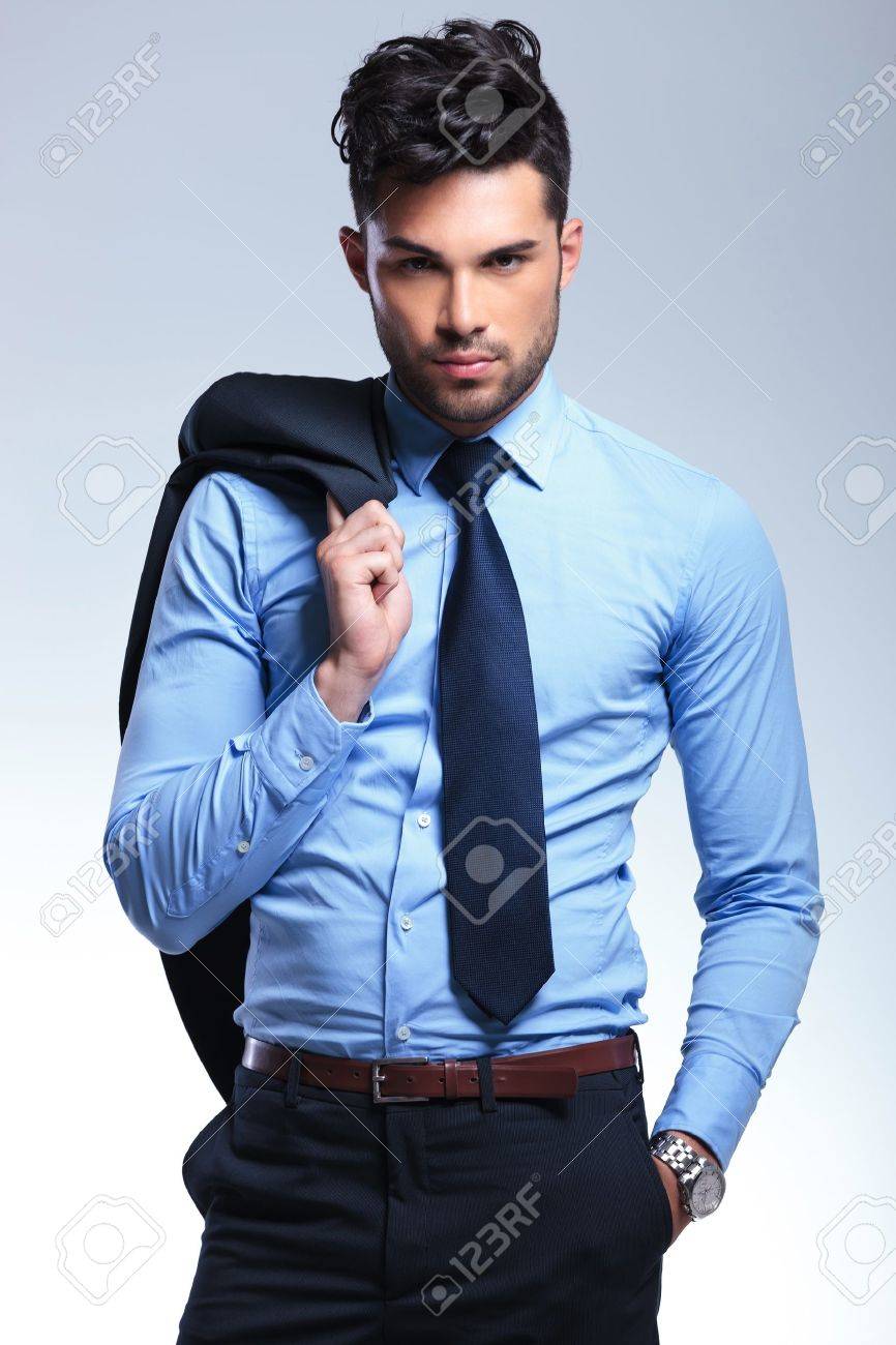 Junge Business Mann Hangt Seine Jacke Auf Seiner Schulter Und Halt Eine Hand In Der Tasche Wahrend In Die Kamera Schaut Auf Einem Grauen Hintergrund Lizenzfreie Fotos Bilder Und Stock Fotografie Image 20677343