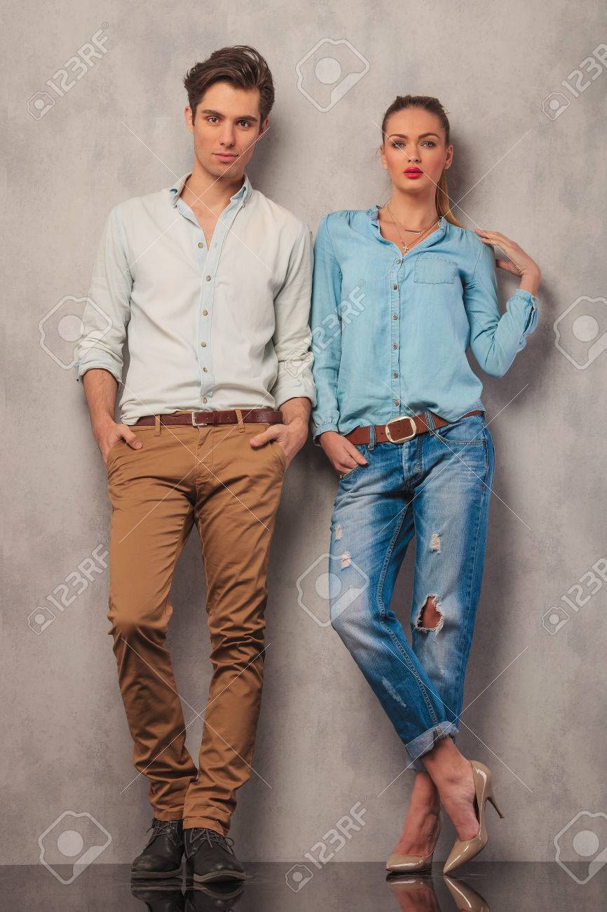 カジュアルなカップル スタジオでポーズをしながら壁にもたれて立って手をポケットに の写真素材 画像素材 Image